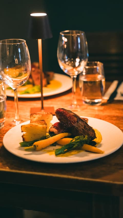 A plated evening main with potatoes, baby carrots and tenderstem broccoli