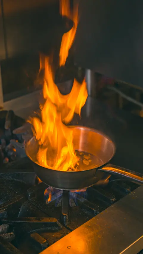 Flames leaping from a pan on the stove in the kitchen