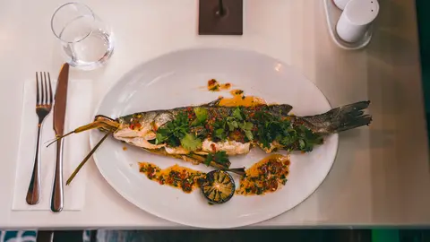 A whole grilled fish dressed with coriander, chilli and a charred lime